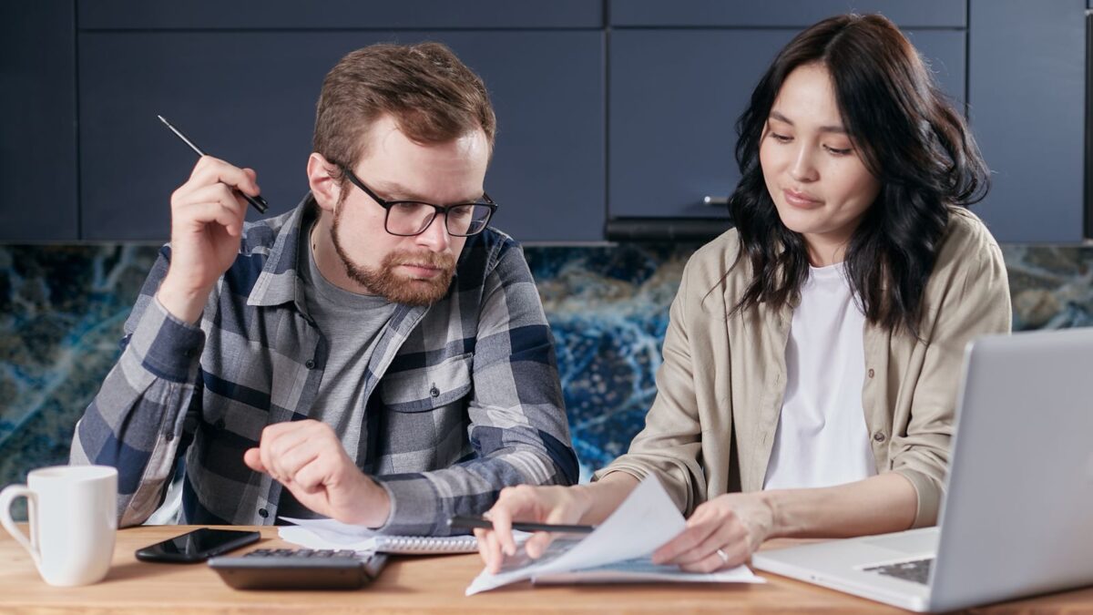 Una pareja revisa facturas y hace cuentas en casa