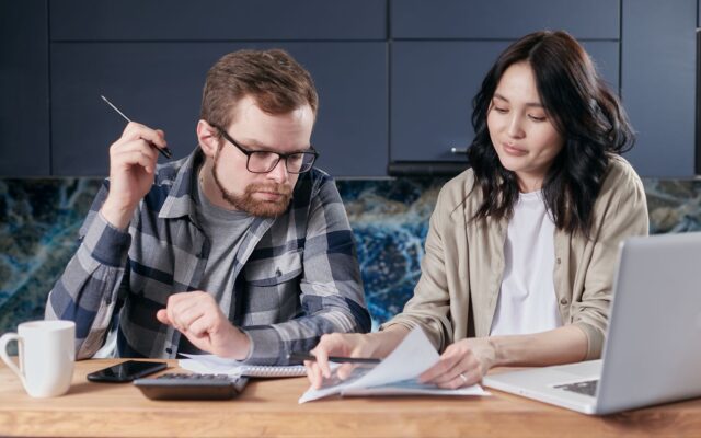 Una pareja revisa facturas y hace cuentas en casa