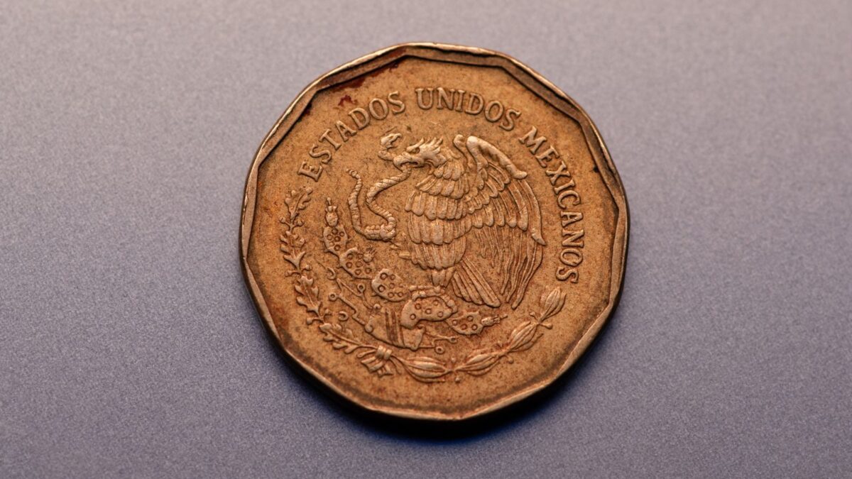 Primer plano de una moneda mexicana con el emblema nacional