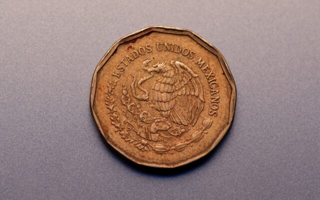 Primer plano de una moneda mexicana con el emblema nacional