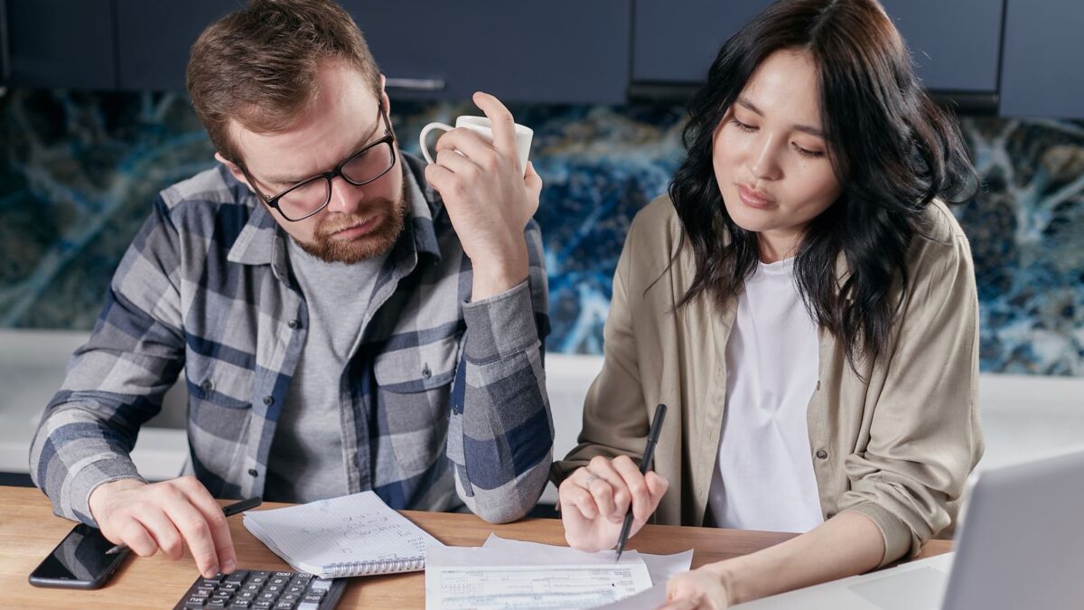 Una pareja revisa facturas y presupuesto con calculadora