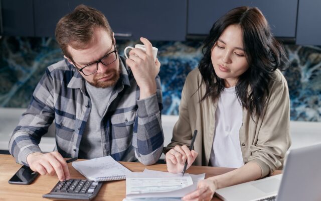 Una pareja revisa facturas y presupuesto con calculadora